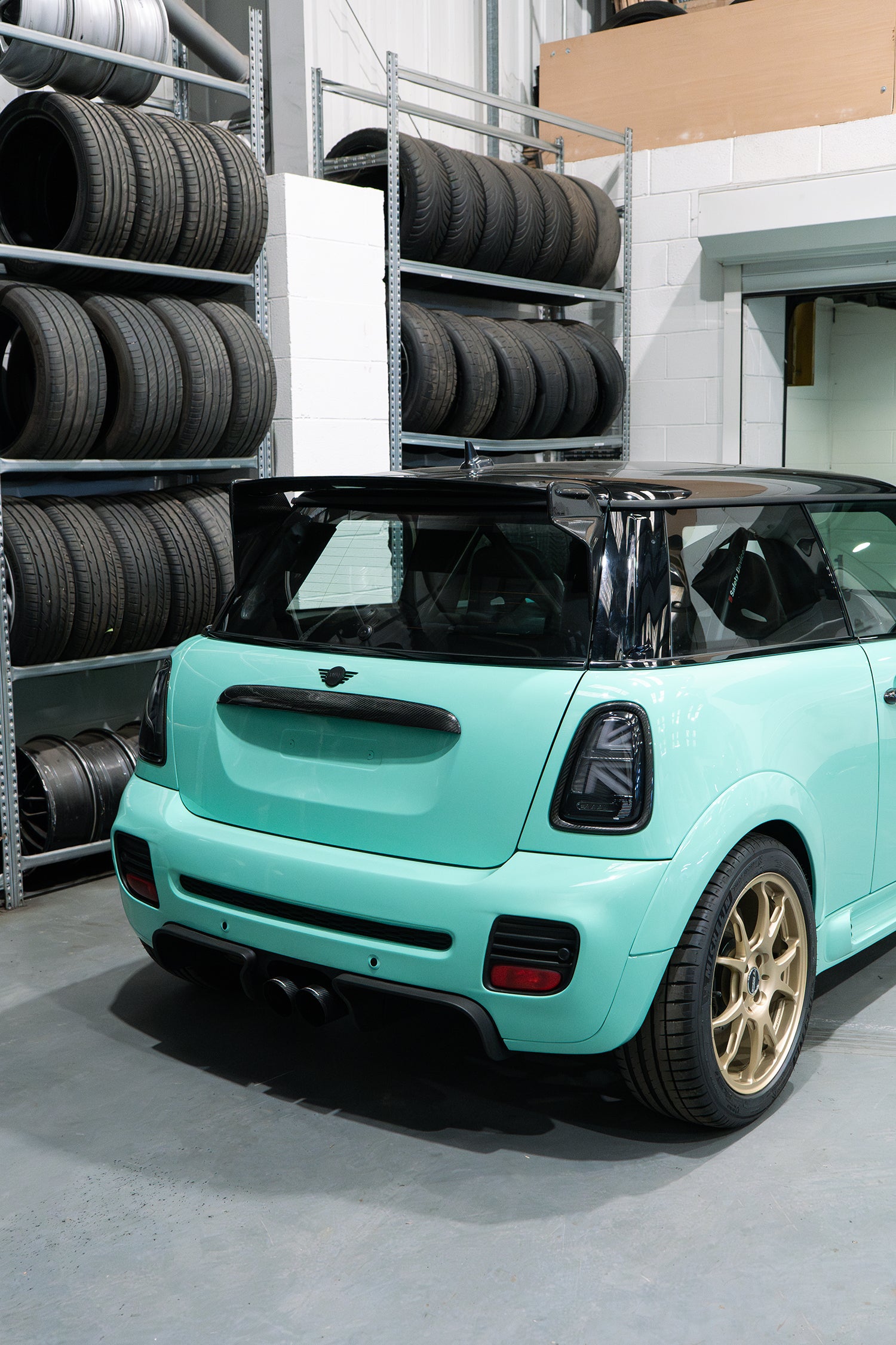 carbon fibre spoiler and Ragazzon exhaust at the rear of a mint green R56 MINI