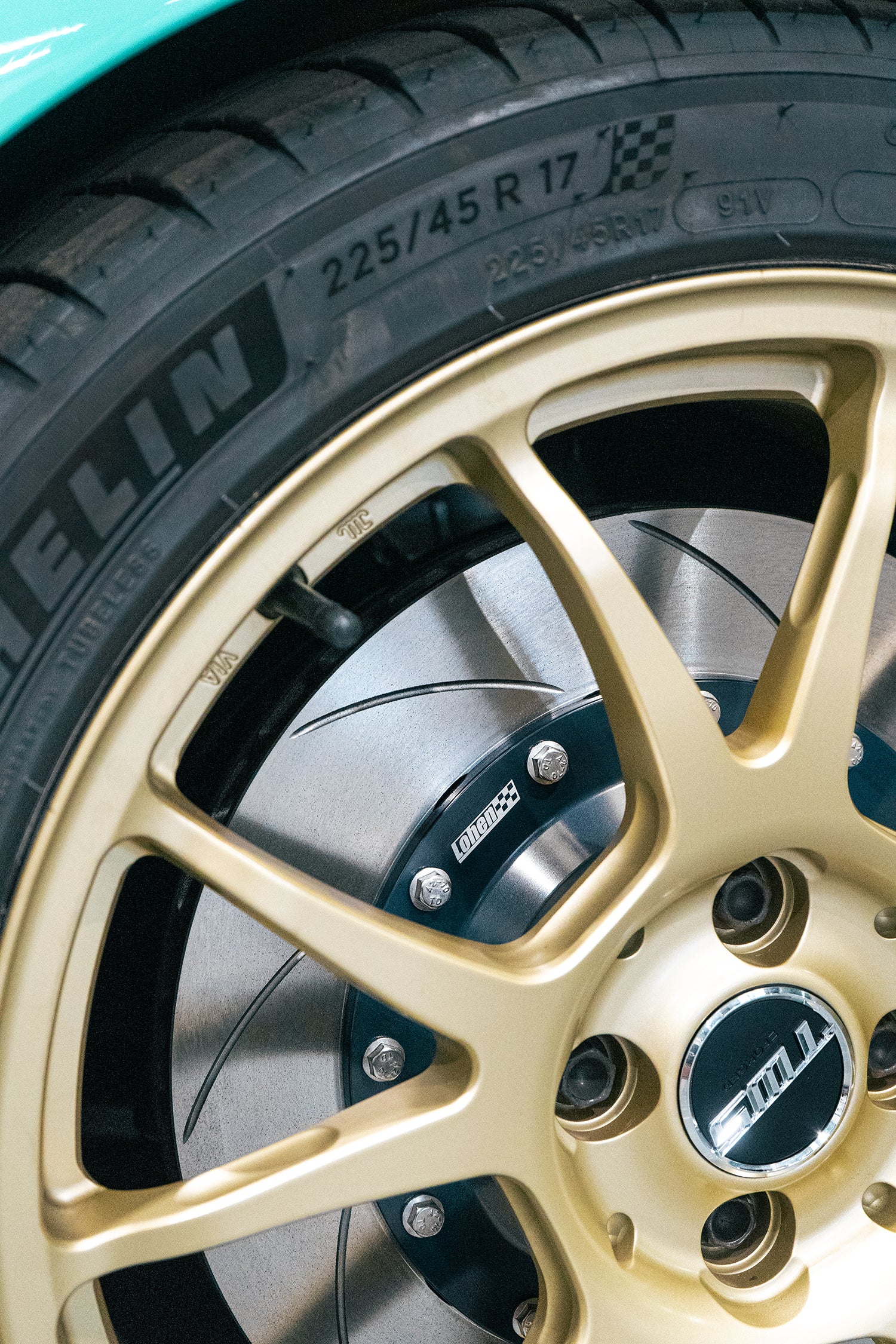 close up of a two piece brake disk behind a wheel on a MINI R56