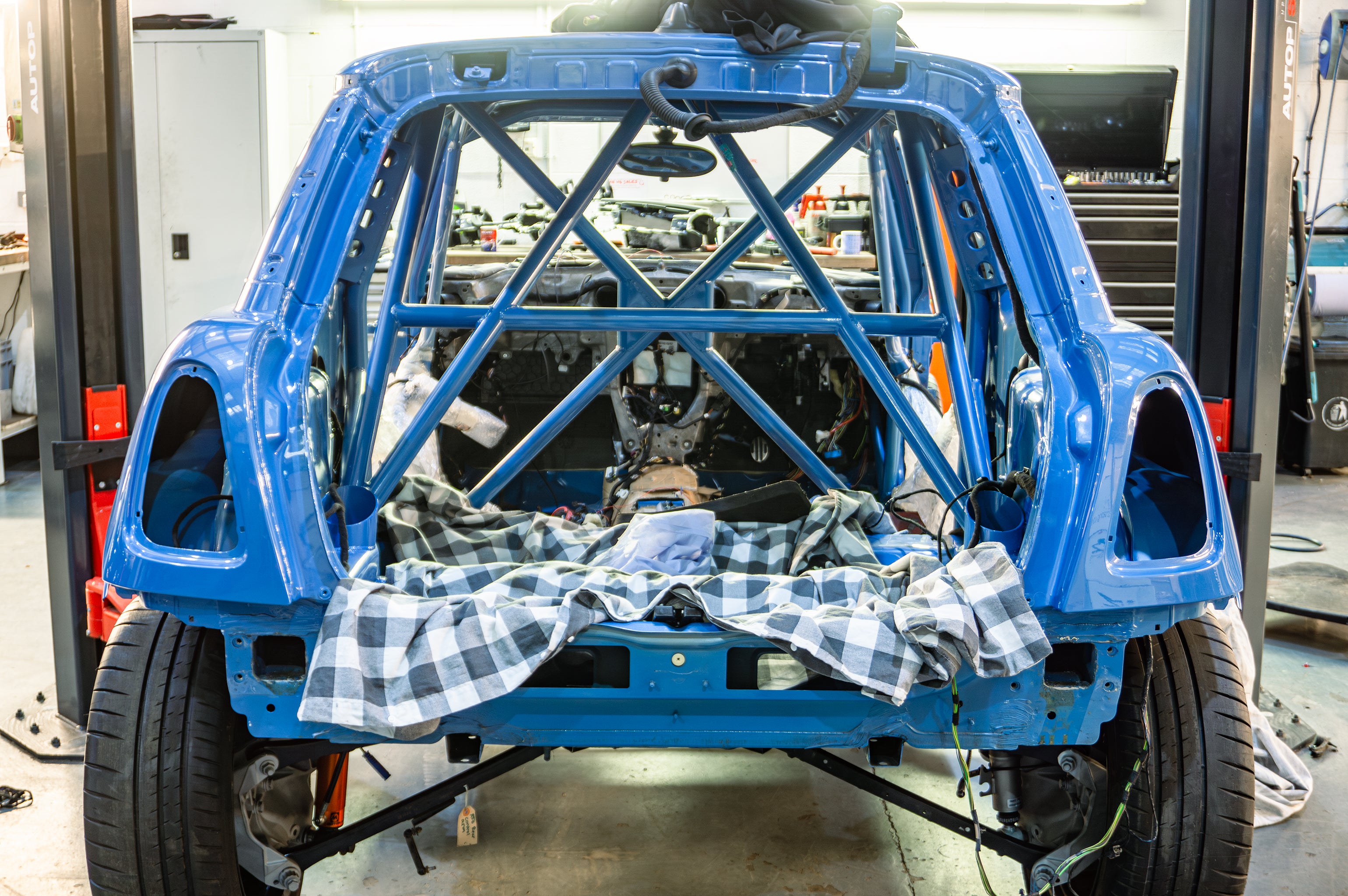 Carousel of images of an R56 MINI getting stripped down ready for painting and then it freshly painted on the ramp at Lohen. AP racing big brake kit fitted and carbon panels.