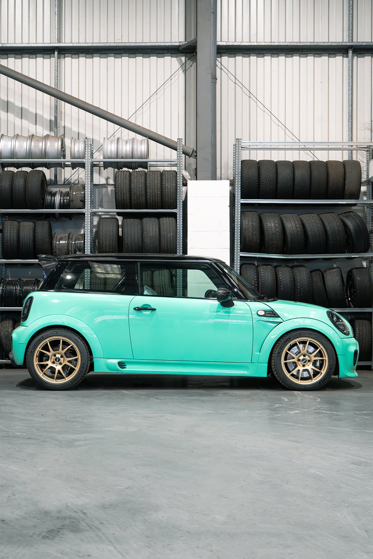 side profile of a mint green custom MINI R56 at Lohen in the workshop