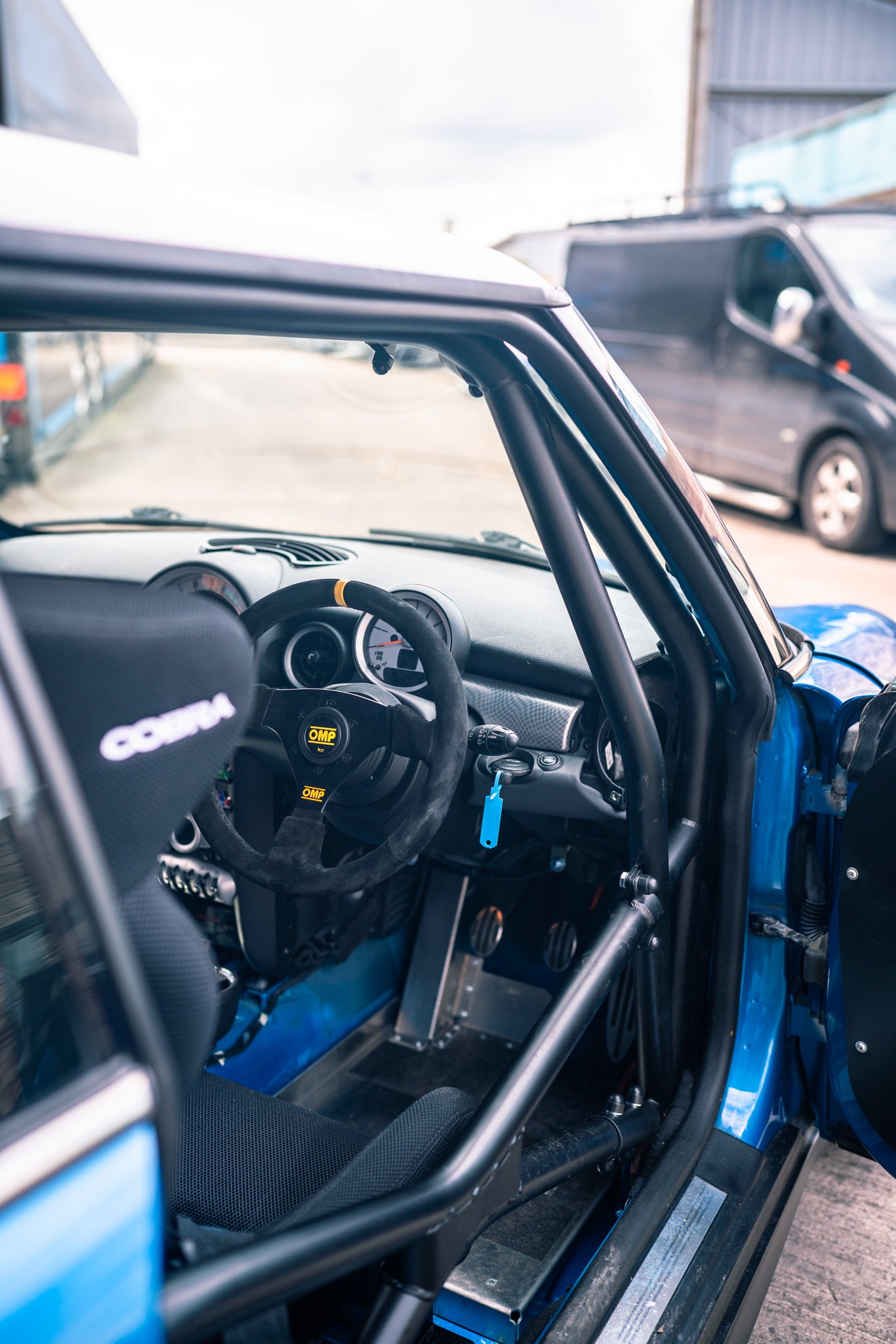 racing steering wheel and roll cage visible through the MINIs window