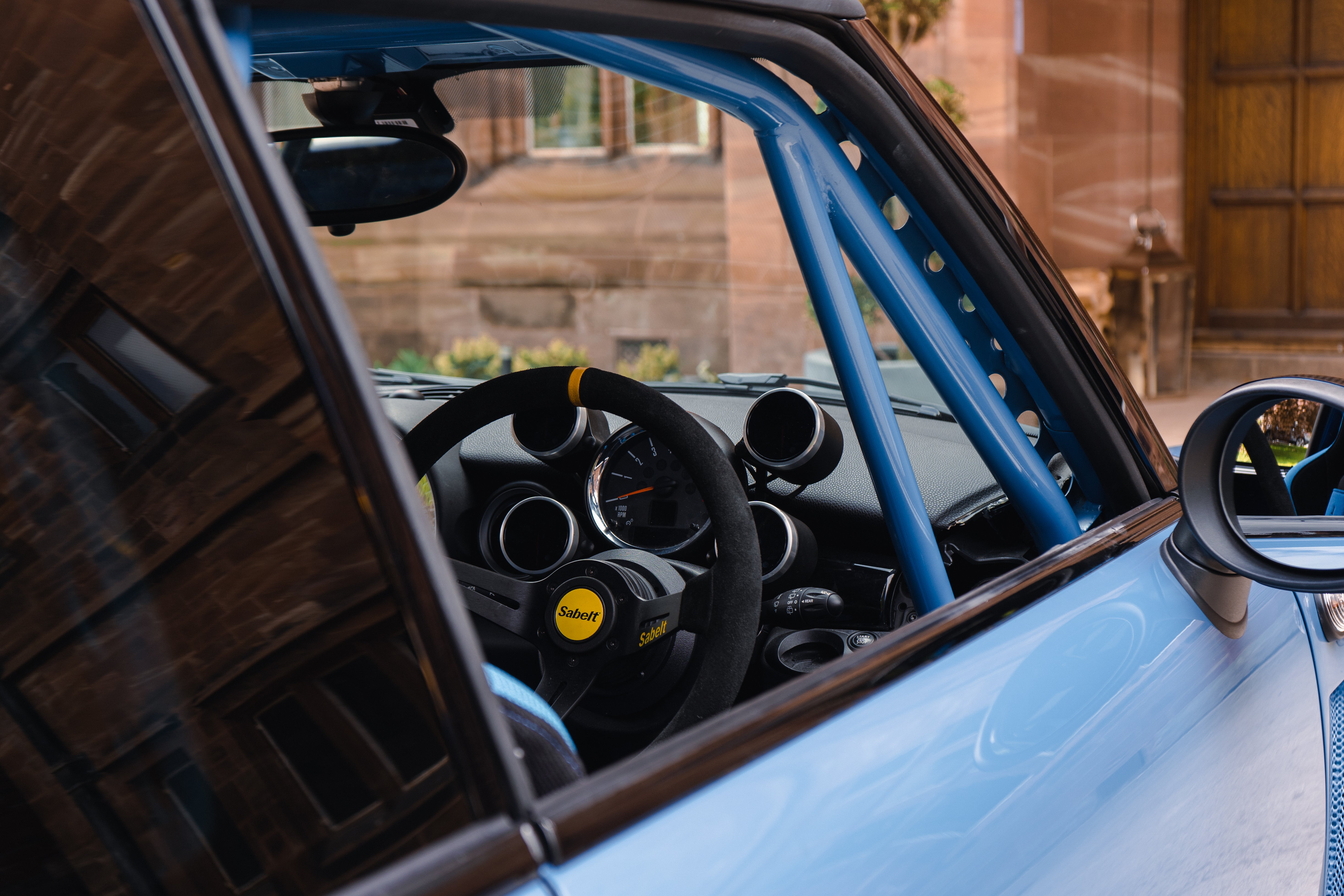 racing steering wheel and roll cage visible through the MINIs window