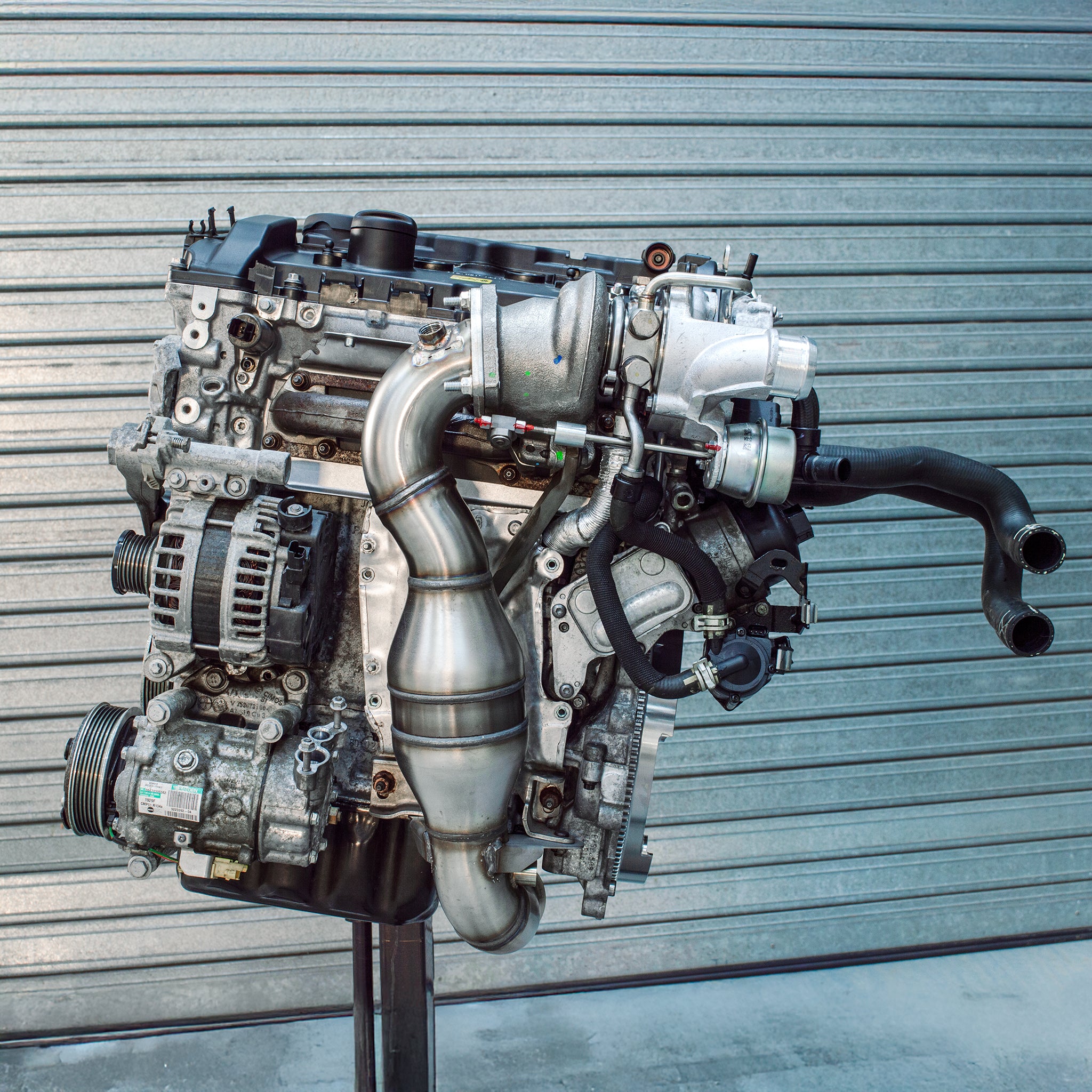 Lohen N18 Crate engine on a stand with sports cat down pipe, light weight flywheel and owen developments hybrid turbo visably attached.