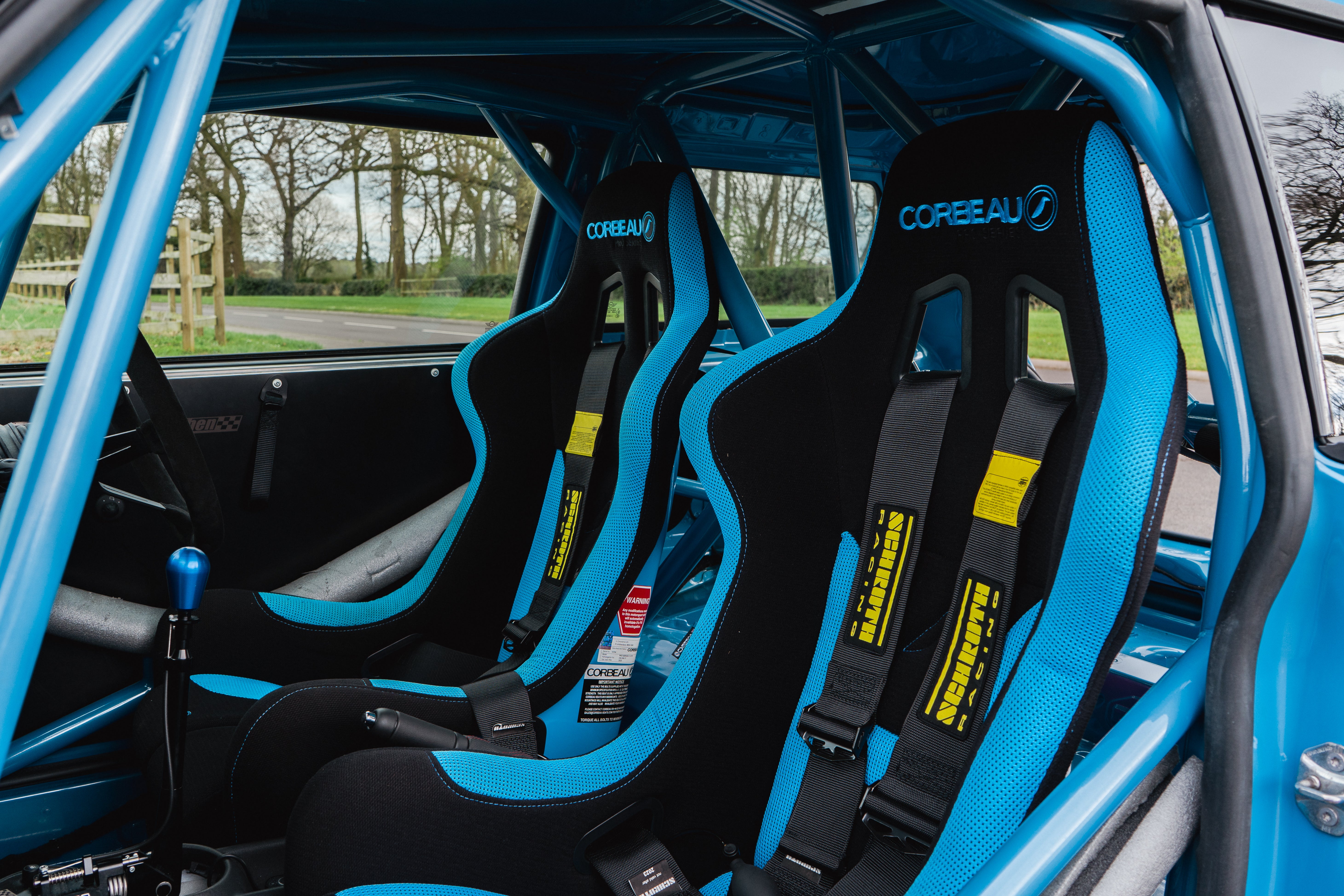 Corbeau bucket seats in black with blue details. Rollcage is painted a matching blue, as is the cars chassis and gear knob.