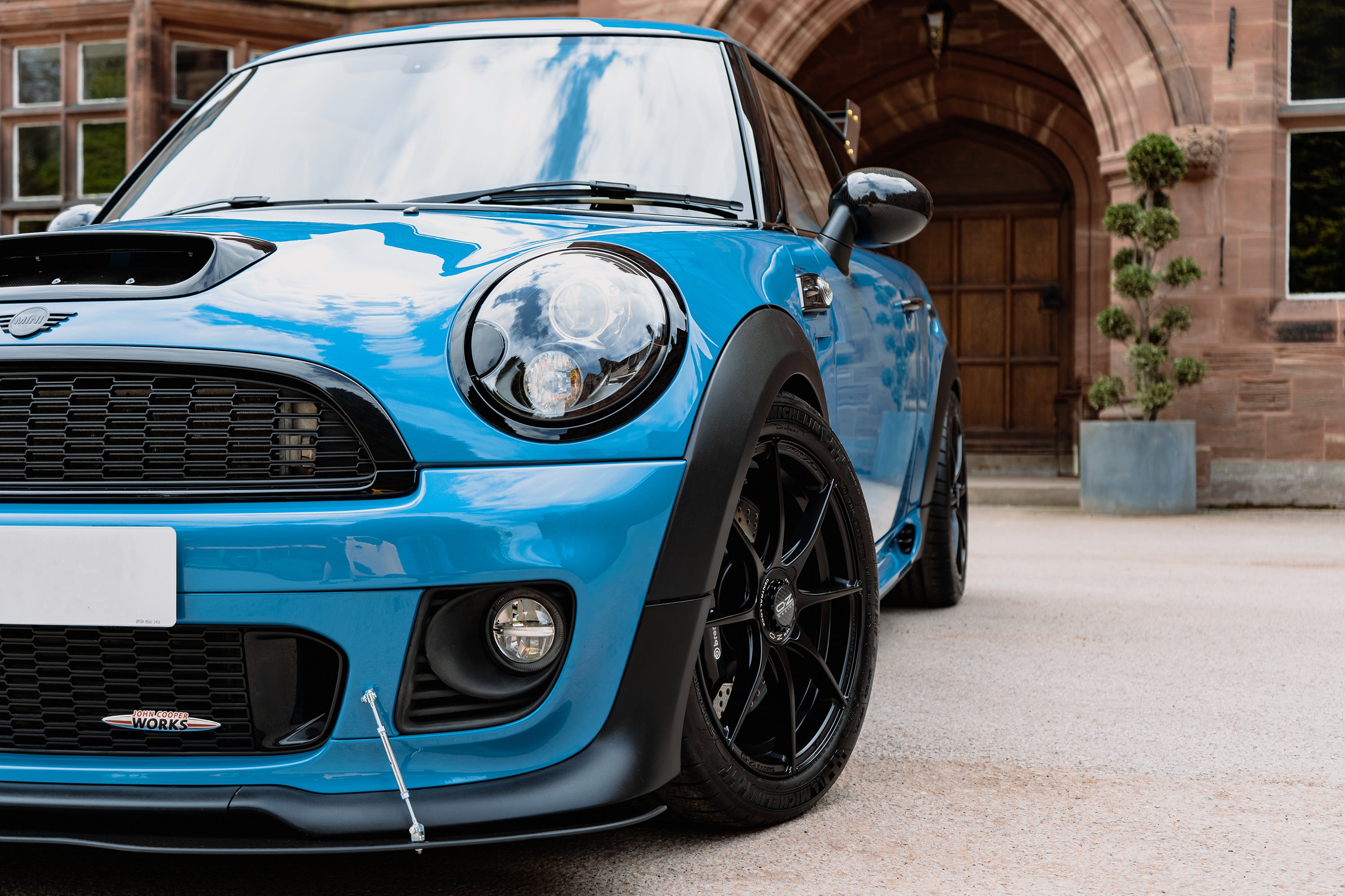 Blue R56 MINI Hatch John Cooper Works with Oz wheels and Brembo brakes parked for a photo shoot